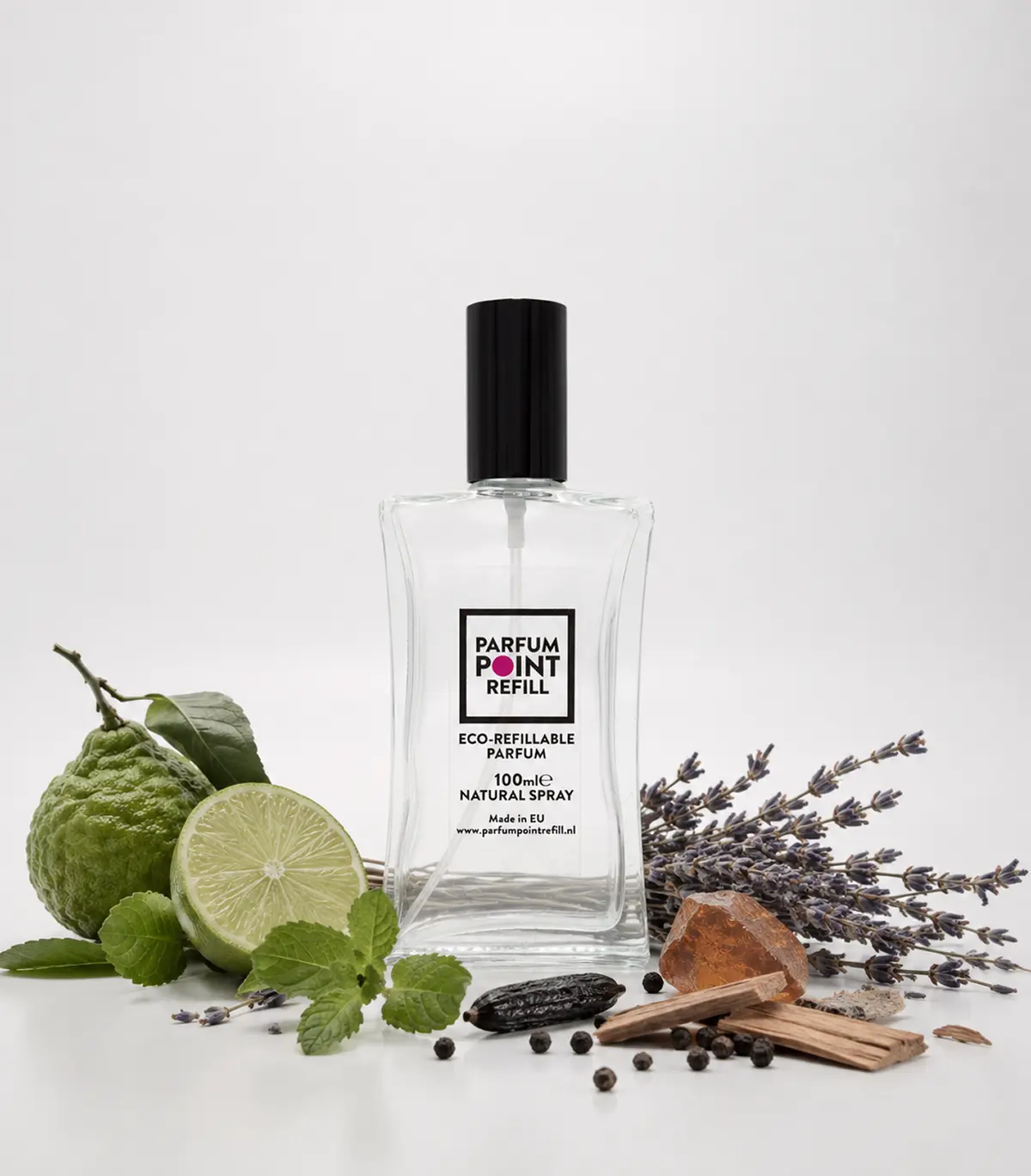 Hervulbaar parfumflesje van ParfumPoint Refill met zwarte dop tussen limoen, lavendel en hout