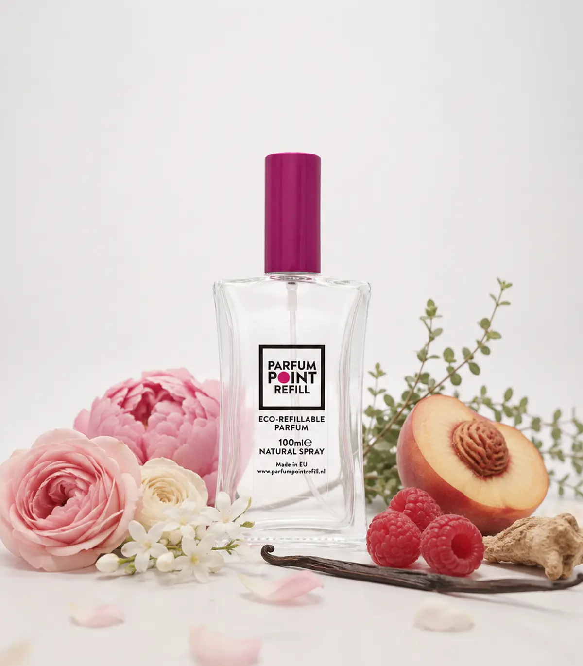 Hervulbaar parfumflesje van ParfumPoint Refill met roze dop tussen rozen, perzik en frambozen